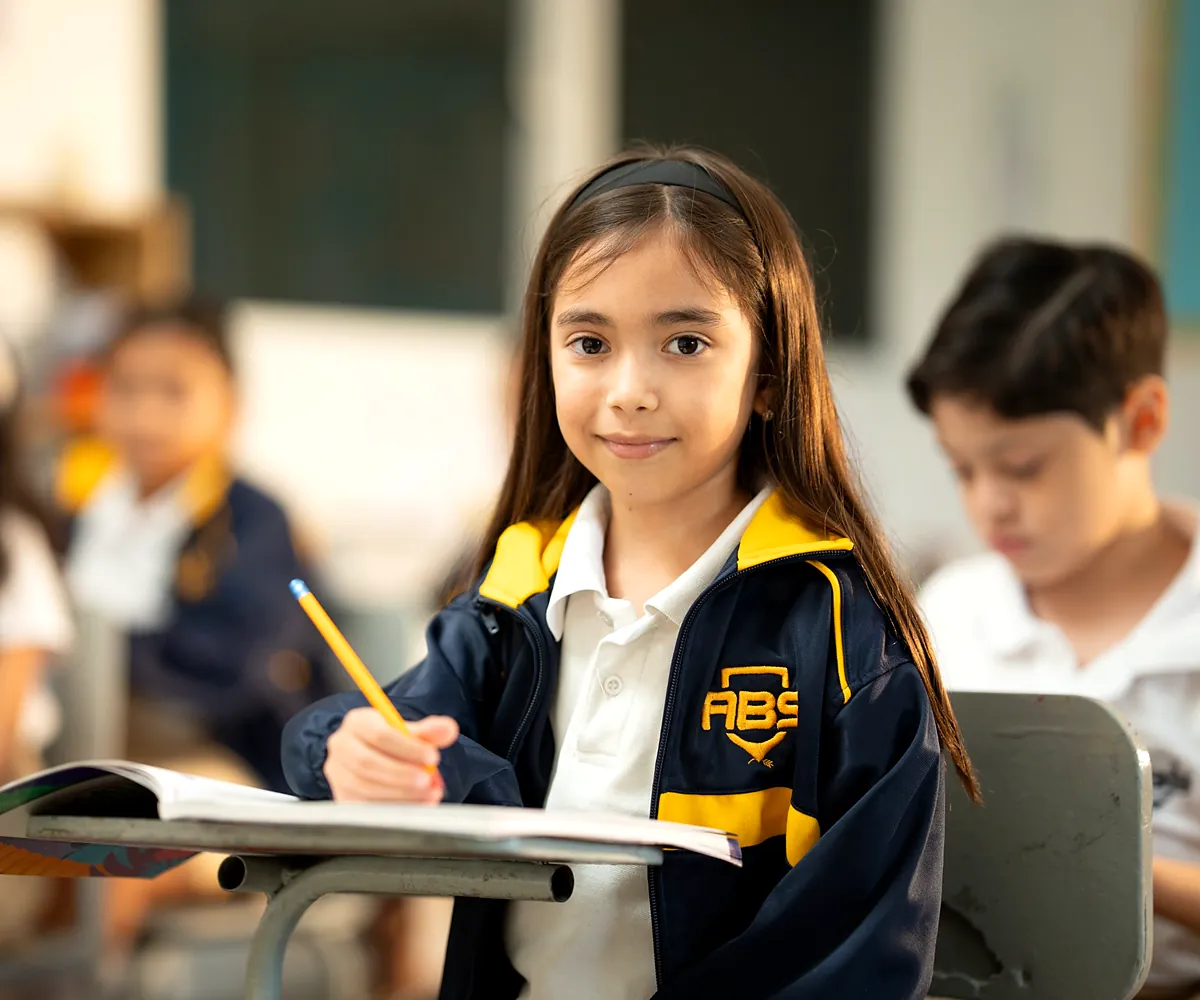 Estudiante de ABS sonriendo en su pupitre